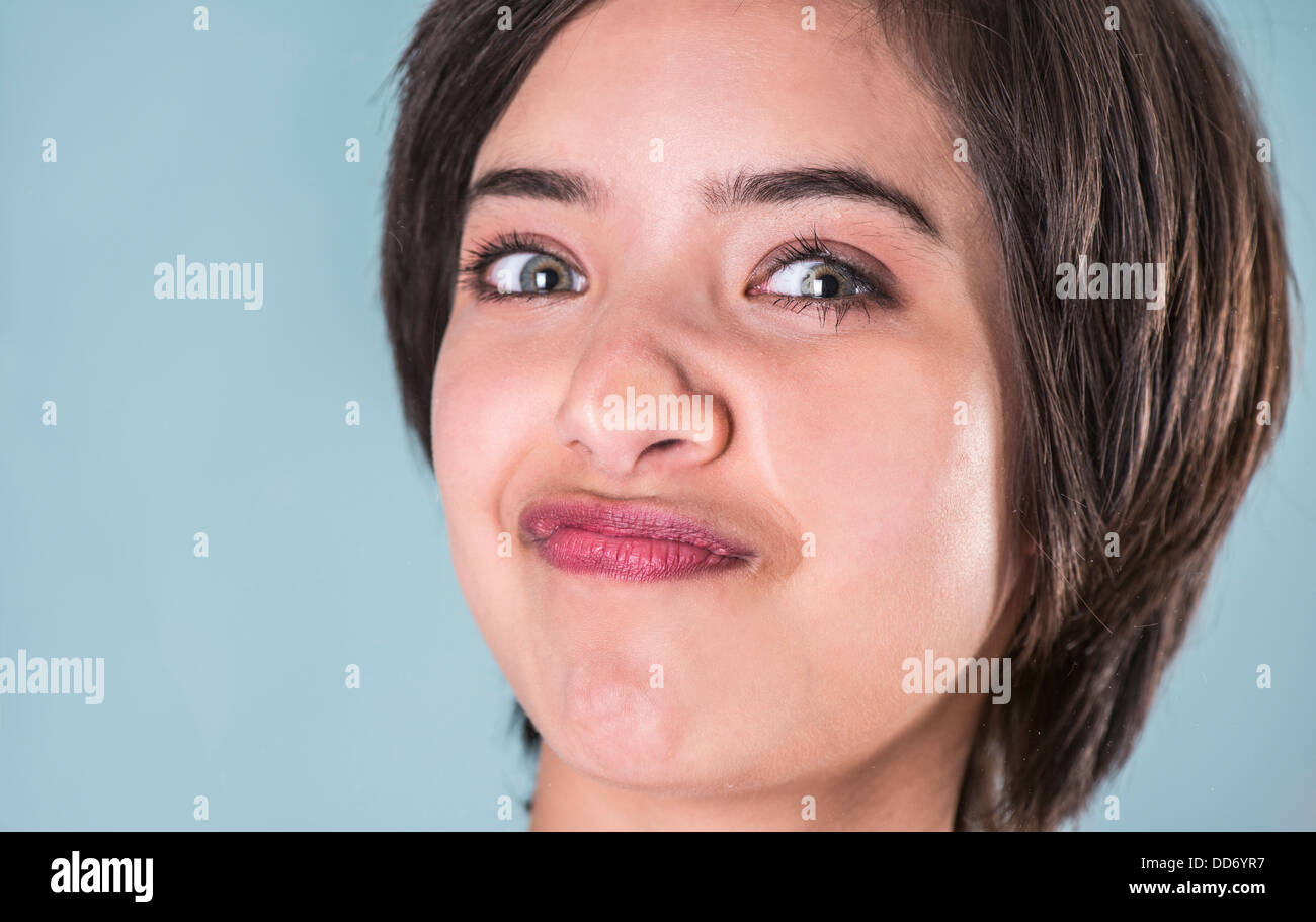 Young woman making funny face squeezing her face against window glass Stock Photo