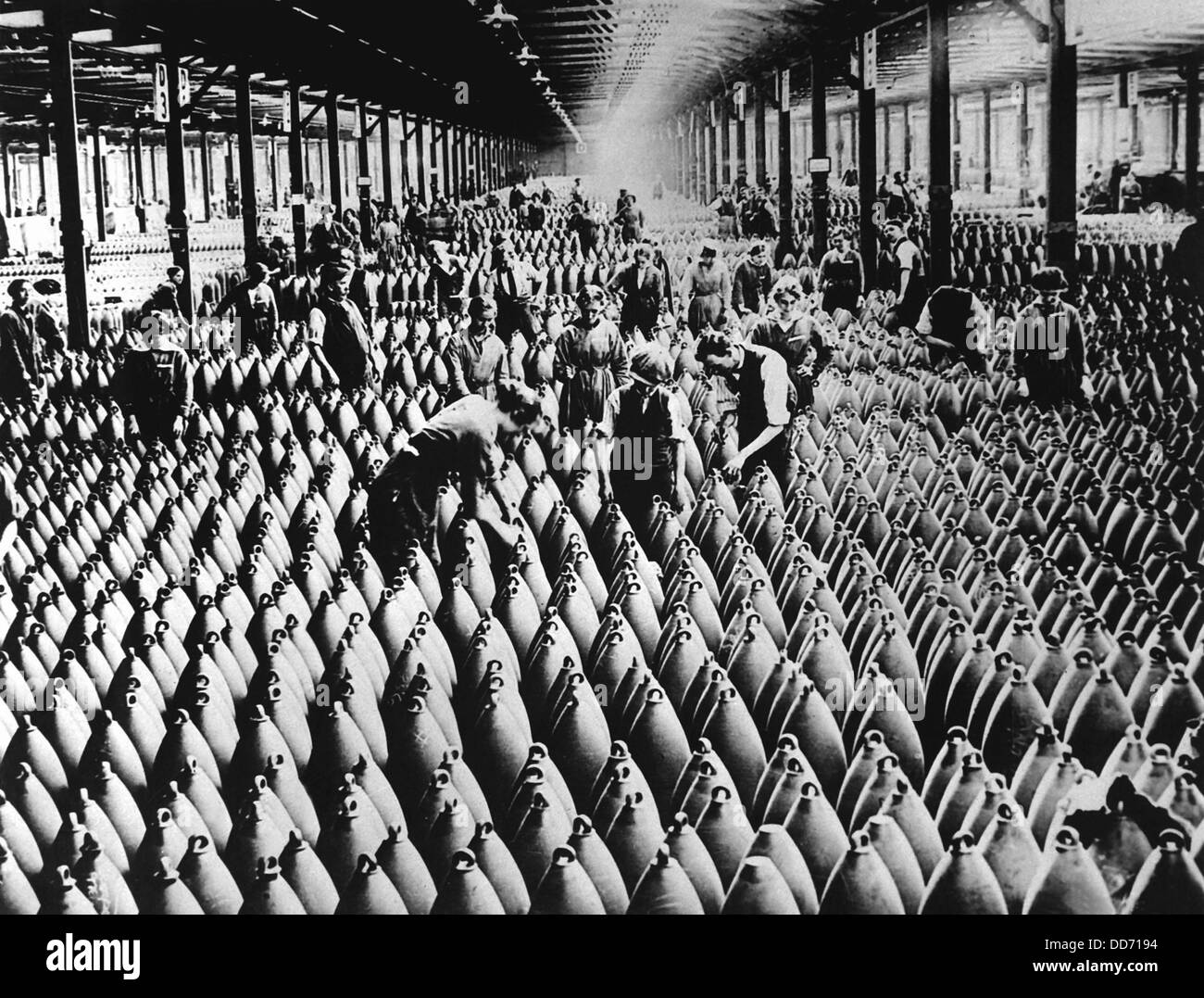 English women and men working in storage shed for large shells of a munitions factory. Artillery was the deadliest weapon of Stock Photo