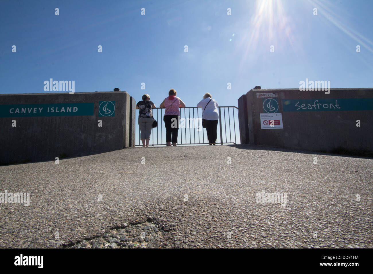 Canvey island Essex UK seafront pensioners looking over barriers into