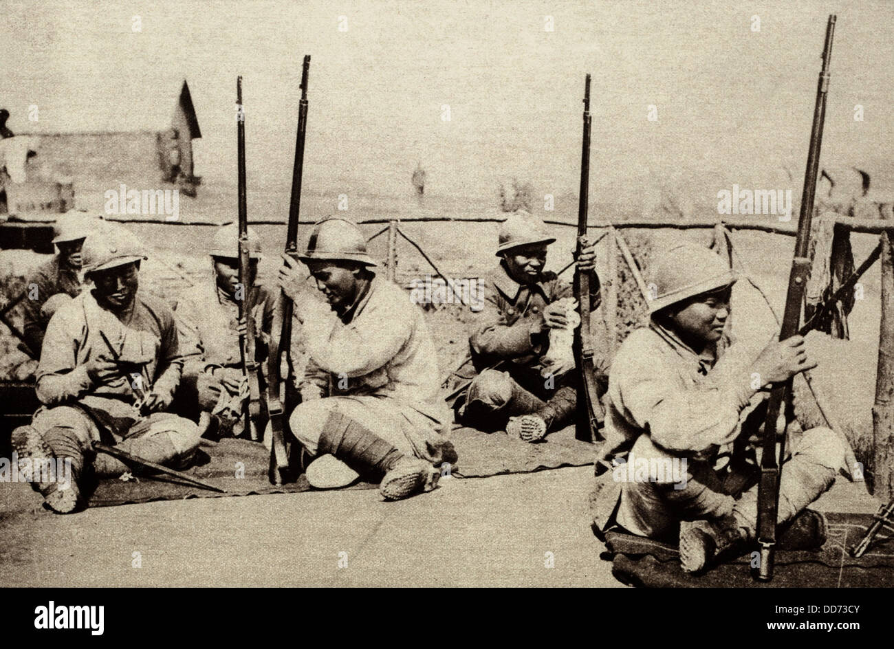 Indochinese from the Annamese region serving as soldiers for France in WW1. 1914-18. They are cleaning their guns in the Stock Photo