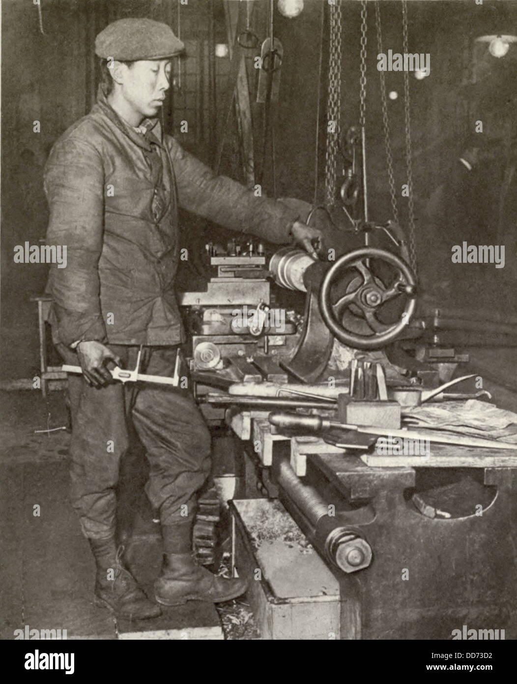 Indo-Chinese workman at ammunition factory lathe in France during WW1. 1916-17. The French colonies of Tonquin, Cochin, and Stock Photo