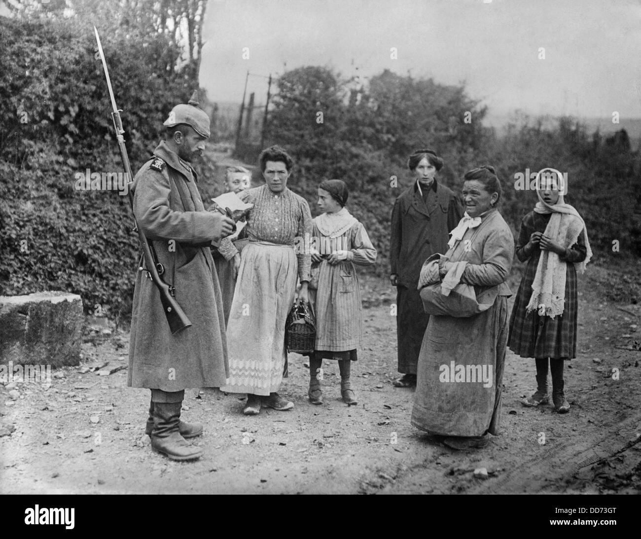 WW1 German soldier inspects documents of women in occupied France. 1915-16. (BSLOC 2012 4 46) Stock Photo