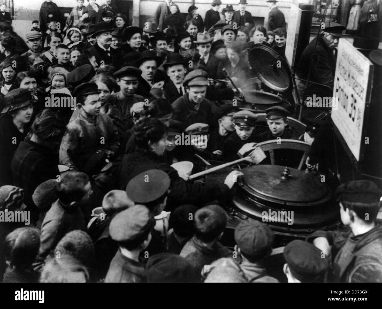 German civilians crowding around soup pots in Berlin during WW1 in 1916. Due to the Allied blockade, food shortages resulted in Stock Photo
