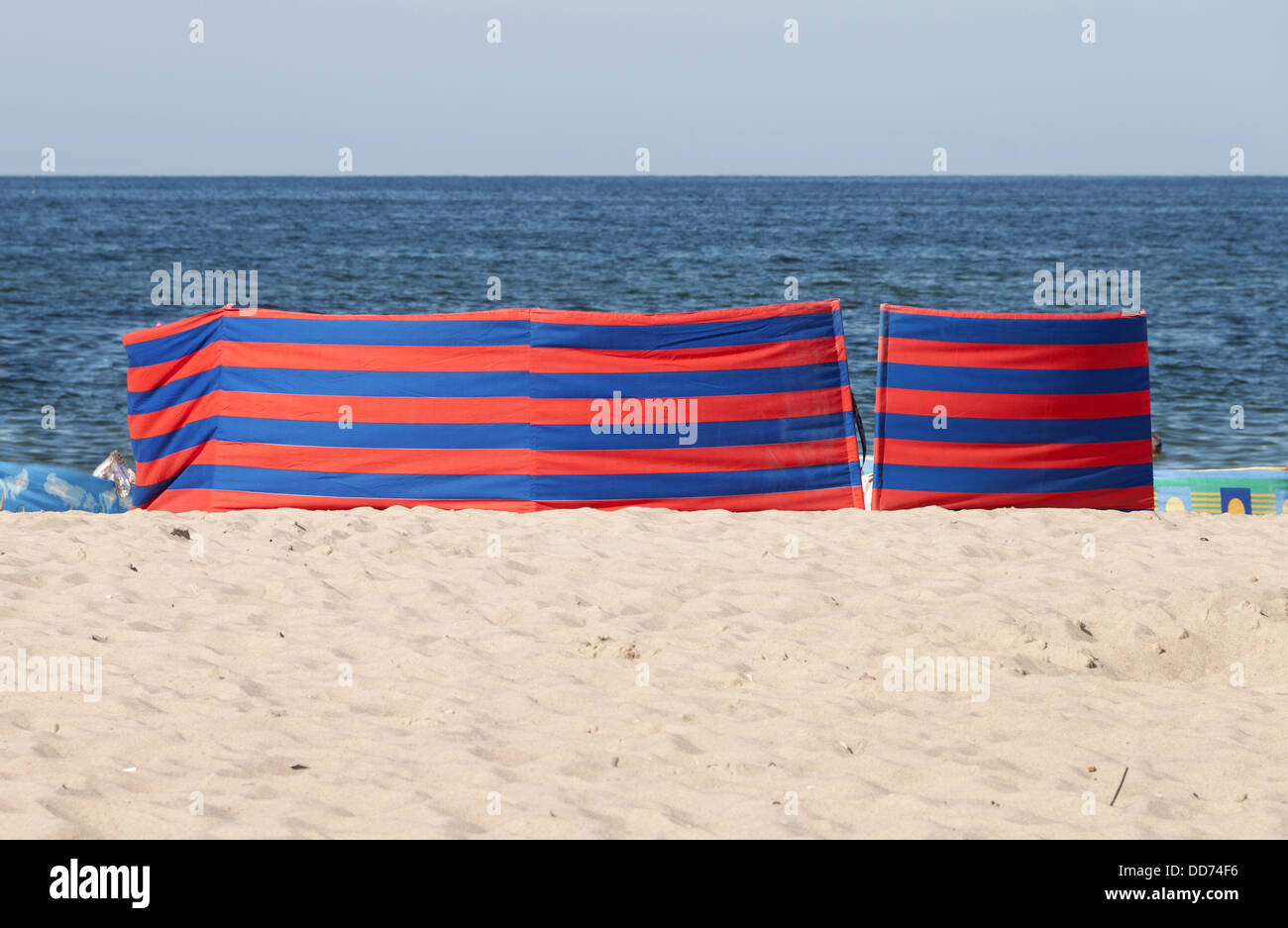 Red and blue striped windbreak at the beach Stock Photo