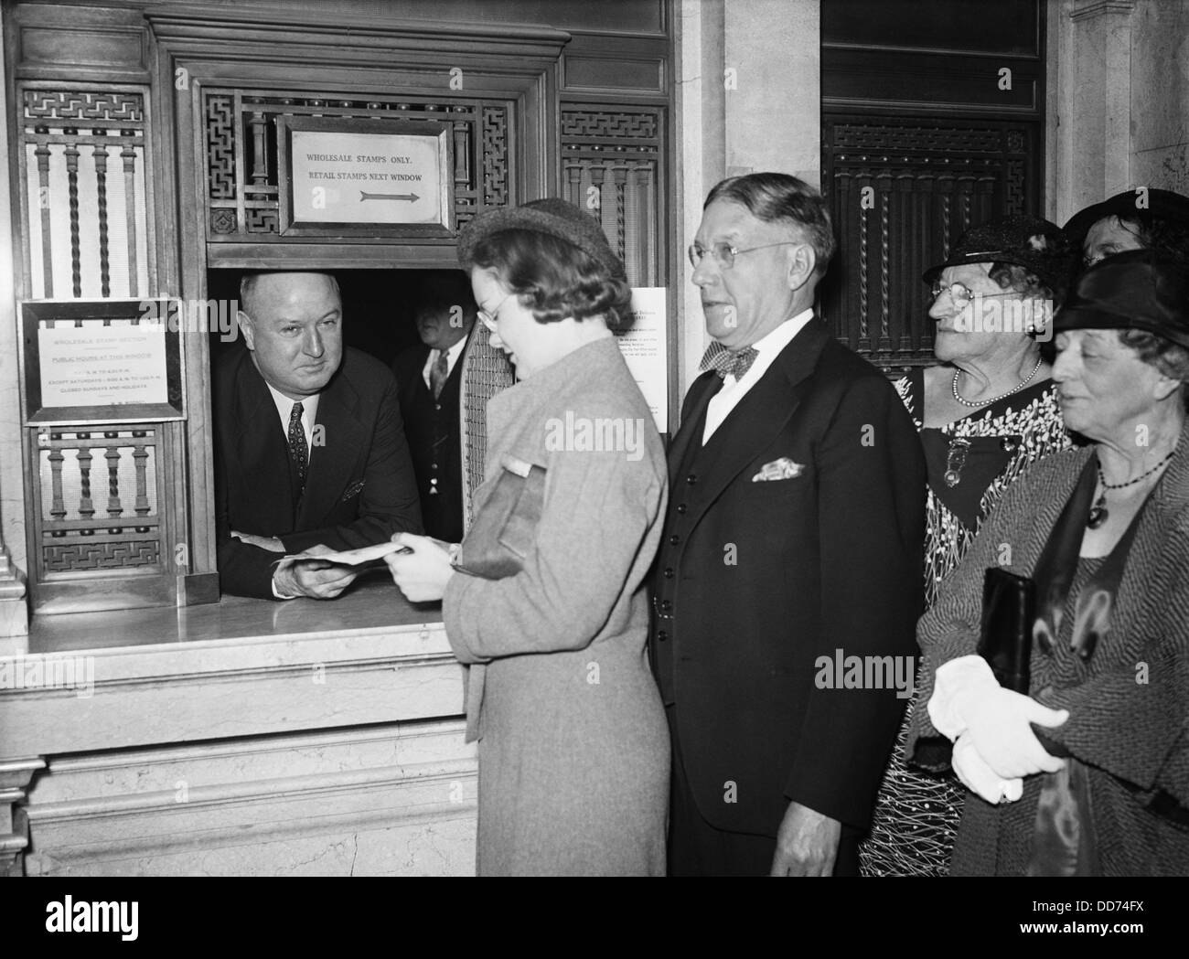 Postmaster James Farley at Post Office service window. 1934. FDR