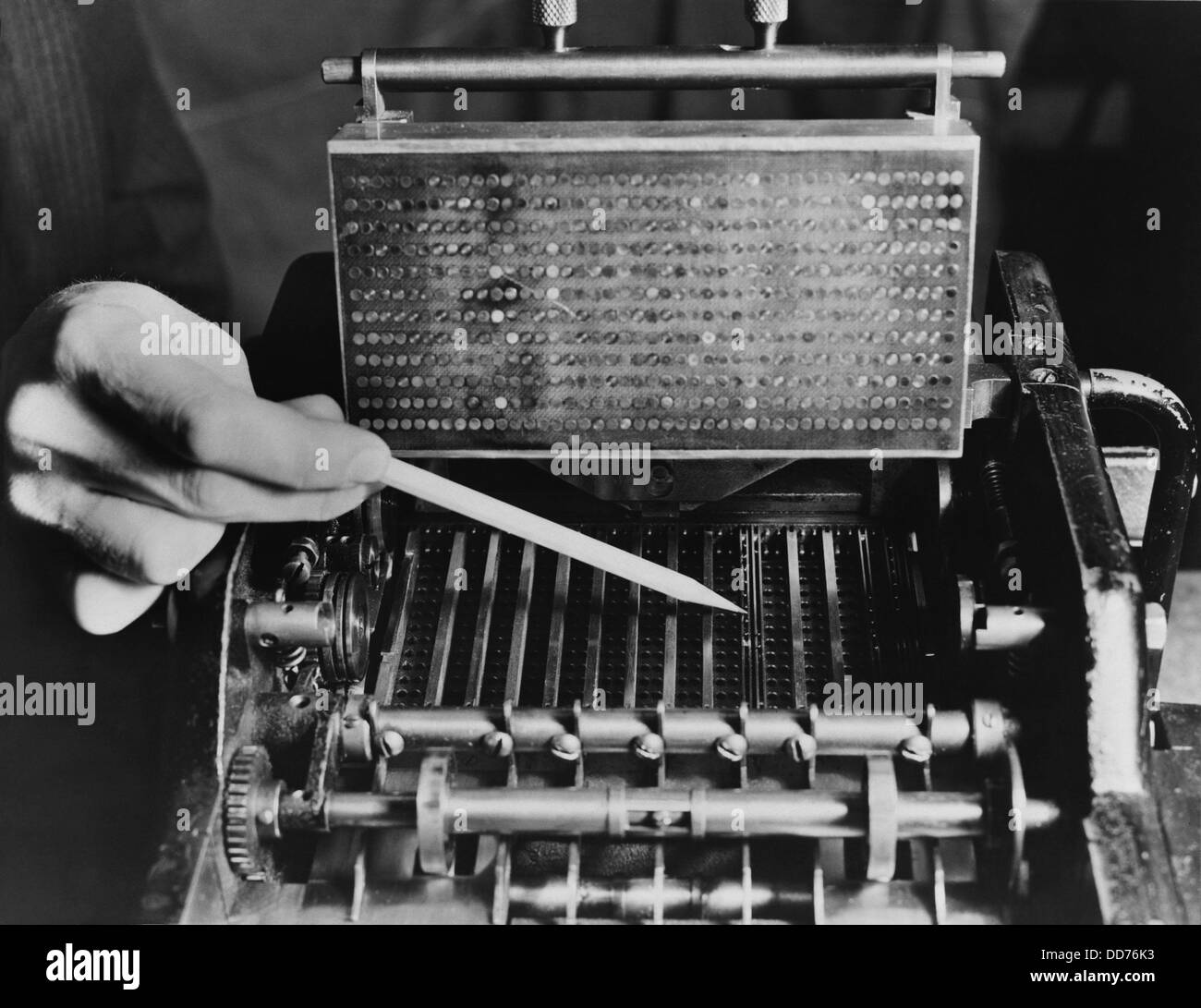 U.S. Bureau of the Census computer operator pointing out the interior mechanism of the punched card sorter, ca. 1940. Stock Photo