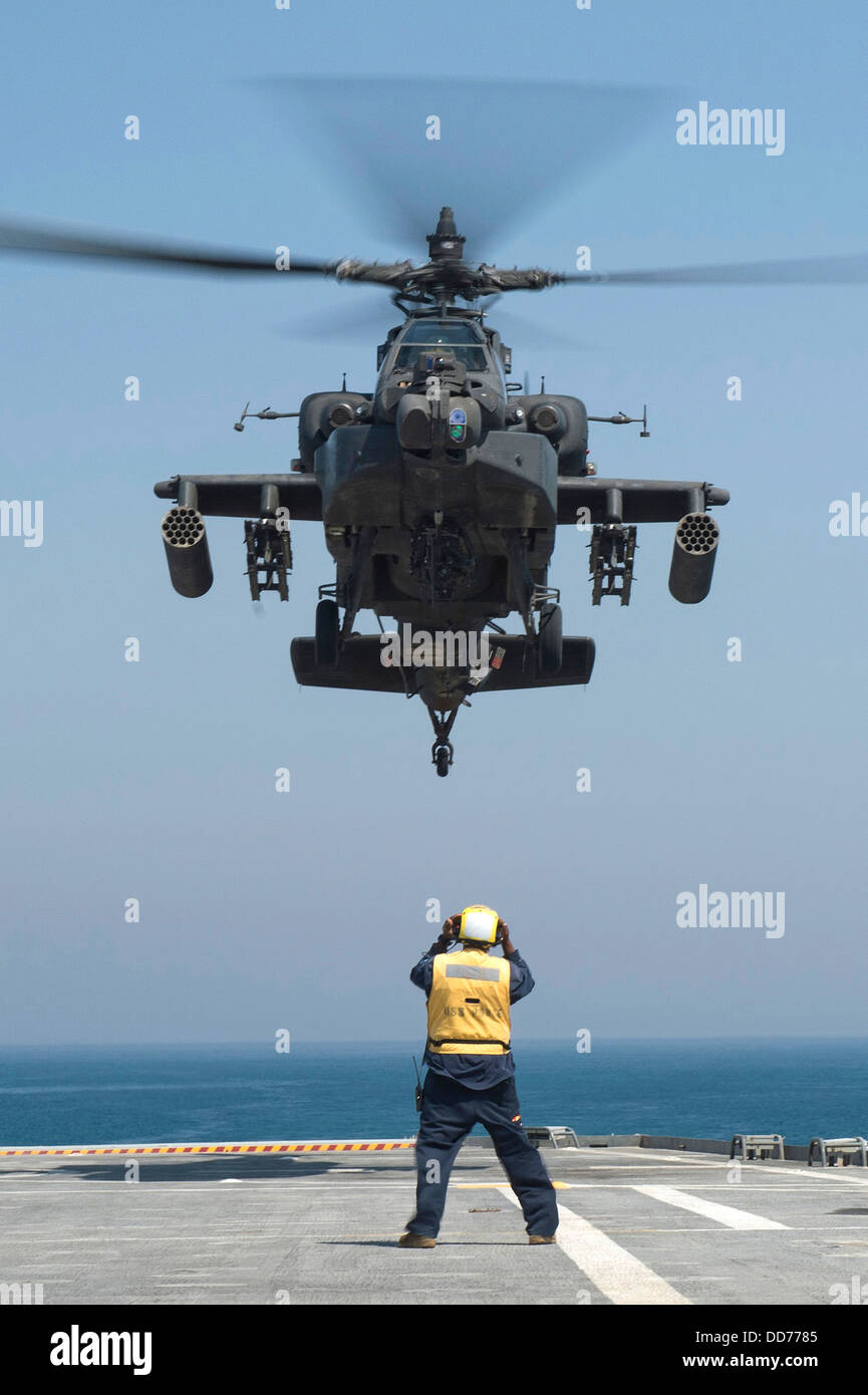 A US Army AH-64D Apache helicopter prepares to land on the flight deck of the USS Ponce during exercise Spartan Kopis August 11, 2013 in the Persian Gulf. Stock Photo
