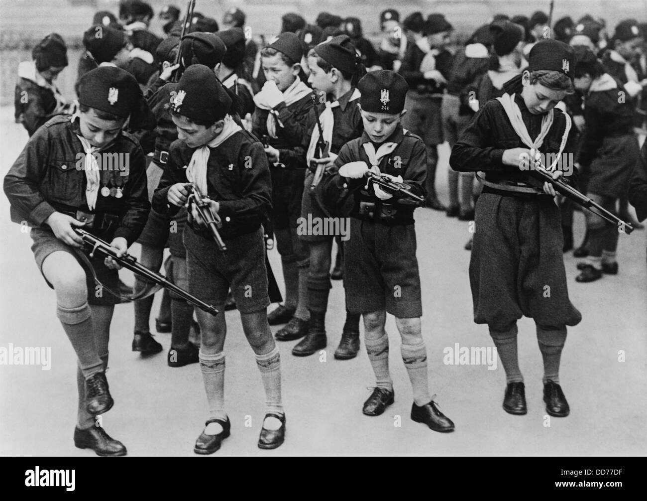 Boys of the Balilla, a fascist youth group, learning to load small rifles. Rome, Italy, 1930s. (BSLOC 2013 9 130) Stock Photo
