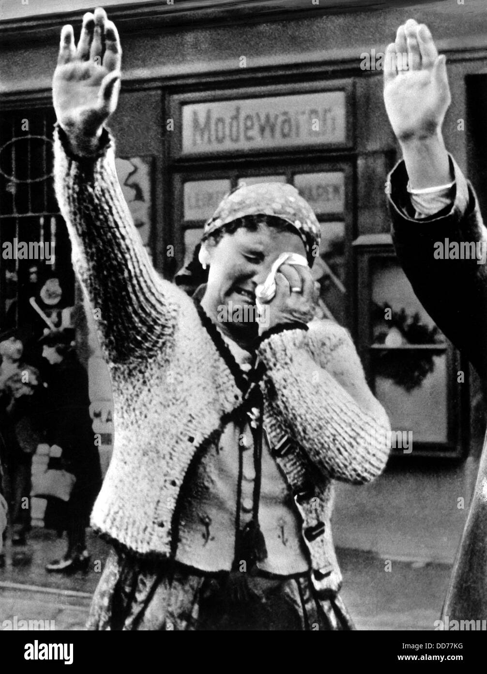 Weeping woman in the Sudetenland saluting the triumphant Hitler in 1938. Debate occurs over her emotion state: Is it joy or Stock Photo