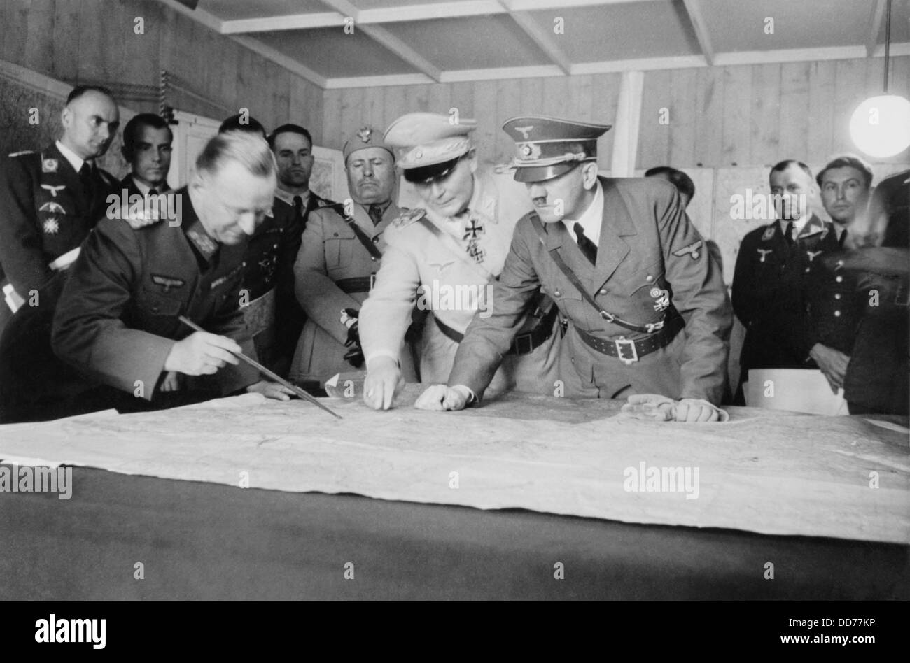 Adolf Hitler, Hermann Goering, and a German officer, looking at map. Behind then are Benito Mussolini and other German military Stock Photo