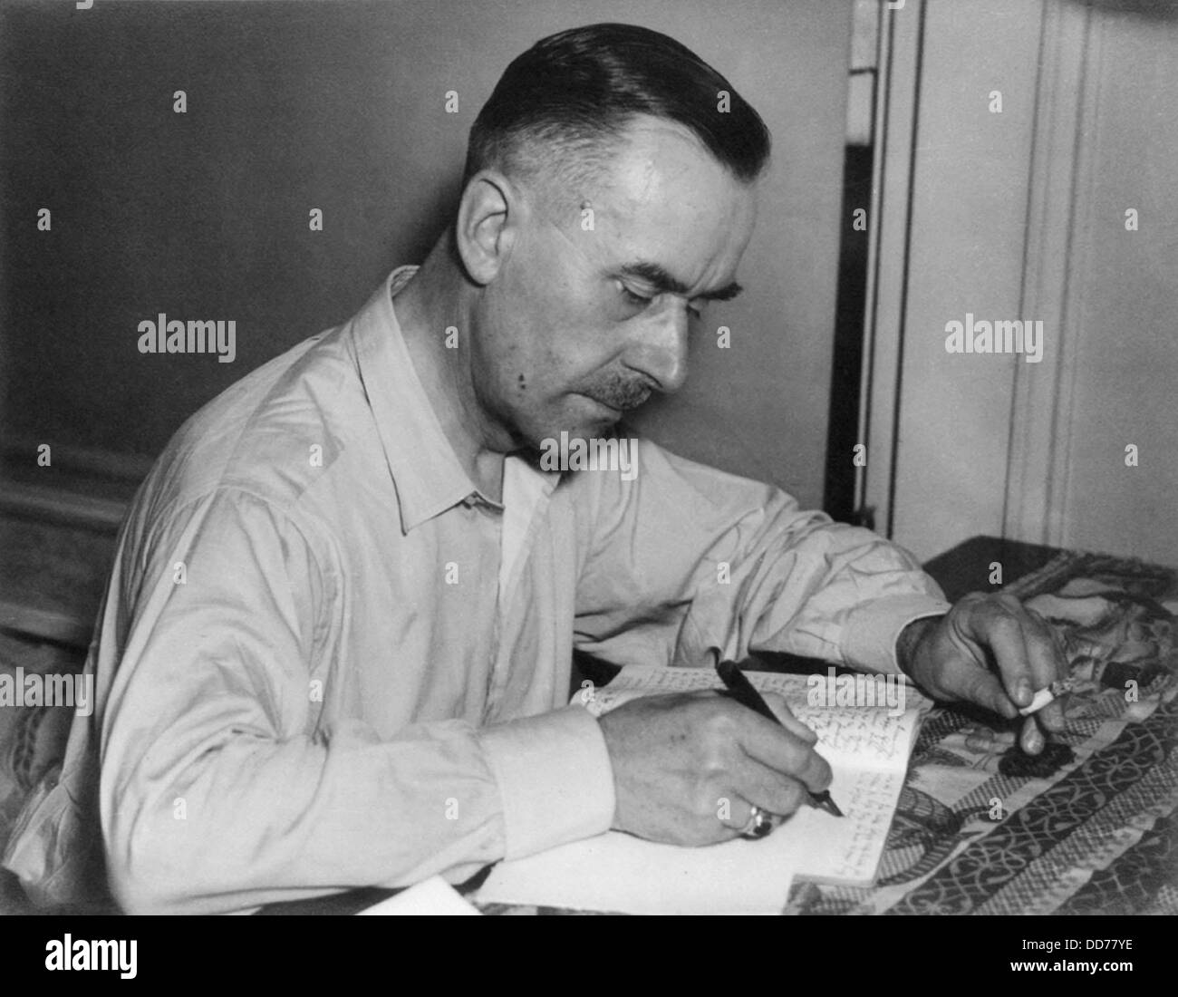 Thomas Mann, German writer and Nobel laureate, writing while holding cigarette. Ca. 1930. (BSLOC 2013 9 57) Stock Photo