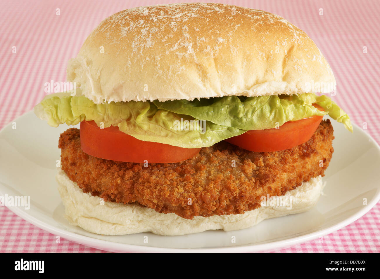 Chicken fillet burger in bread crumbs with lettuce and tomato on a