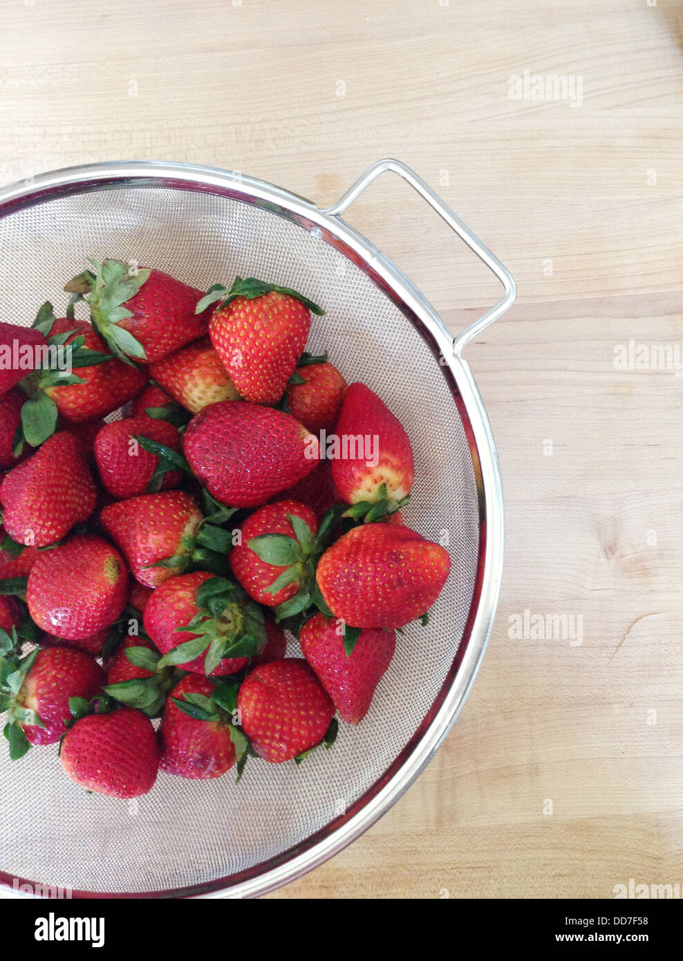 Sieve of strawberries on counter - Smartphone Captured Stock Image