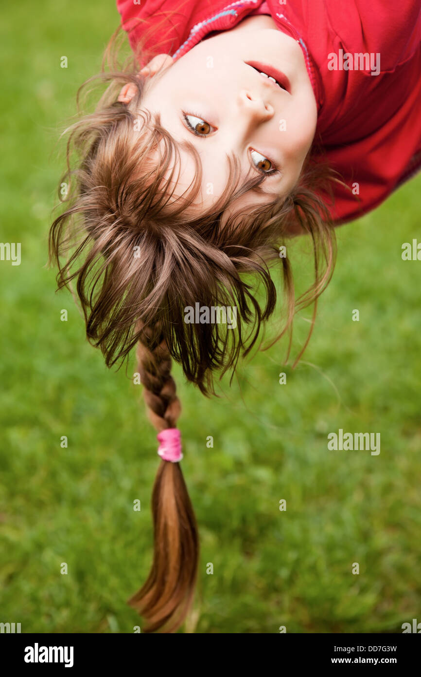 Little girl hanging upside-down Stock Photo