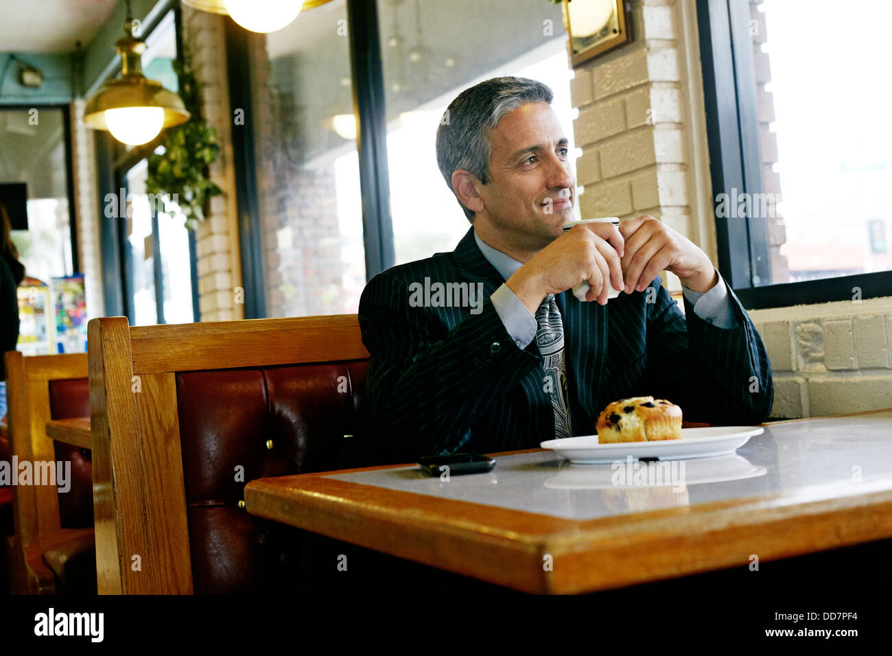Hispanic businessman having coffee in restaurant Stock Photo
