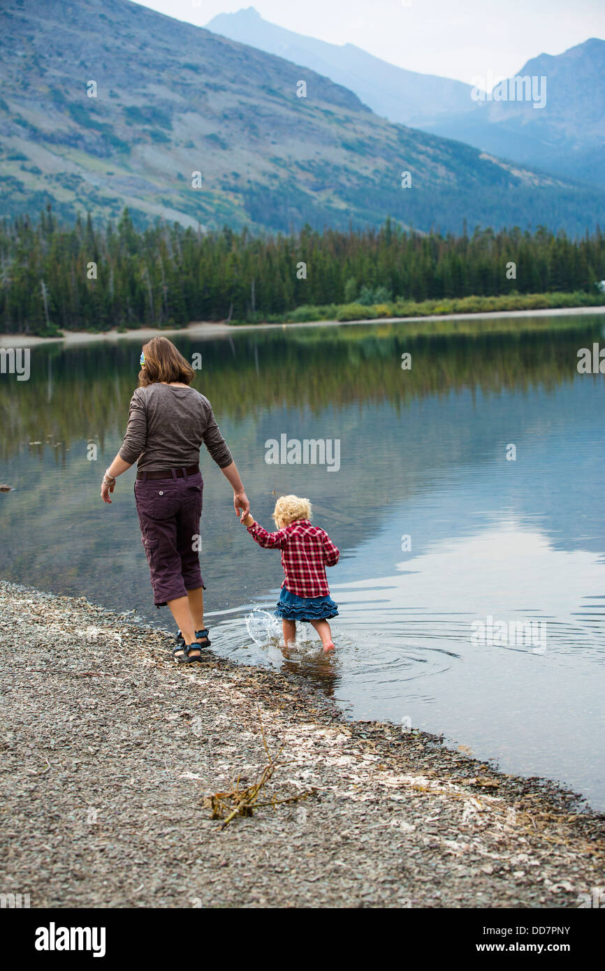 Mother and child walking in still rural lake Stock Photo