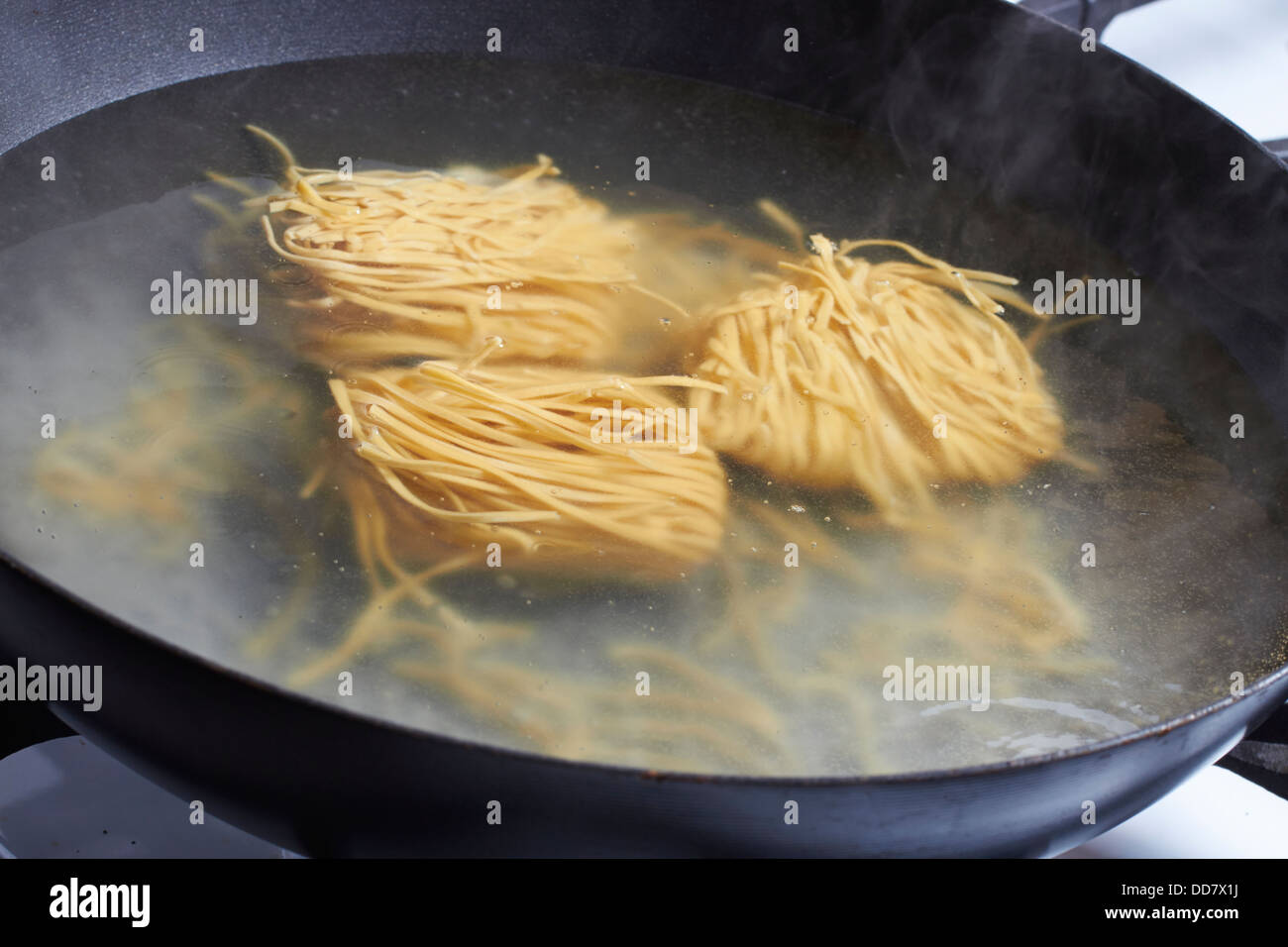 cooking Chinese egg noodles in a wok Stock Photo Alamy
