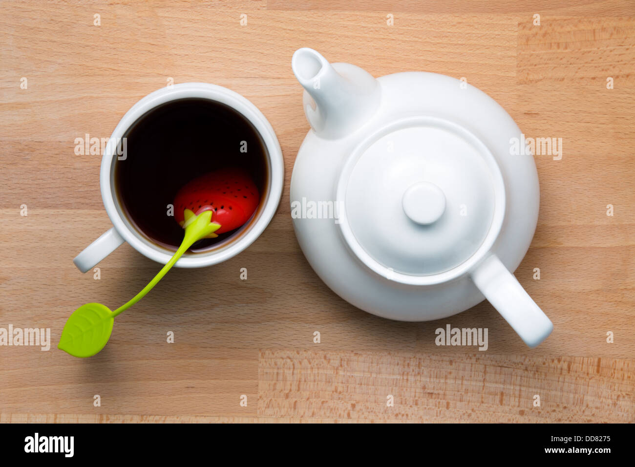 Infused tea and teapot next to each other on beech wood, shot from top