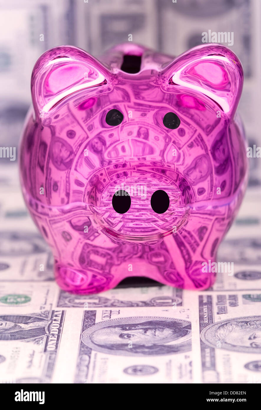 A pink shiny piggy bank surrounded by dollar bills and reflecting them ...