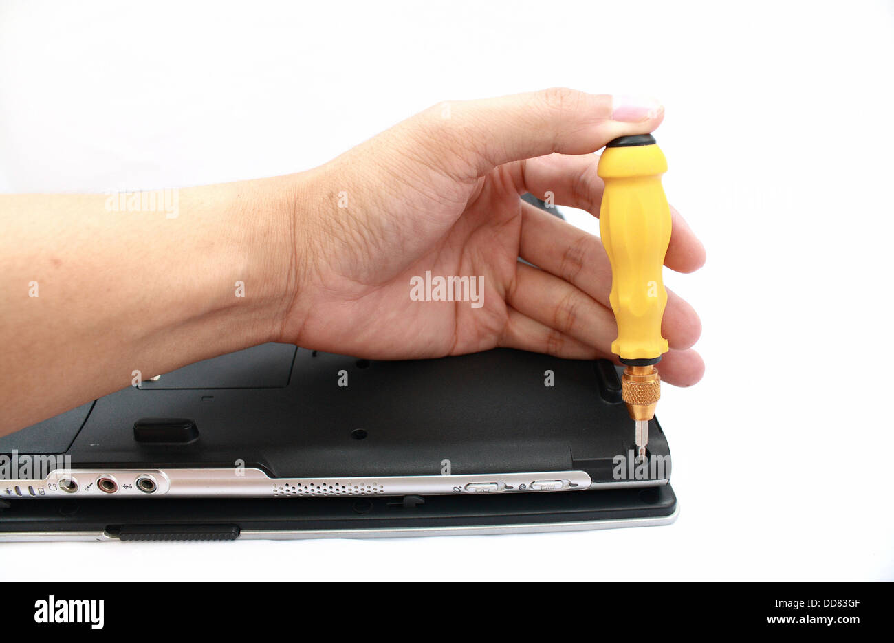 a hand with screwdriver fixing a computer. Stock Photo
