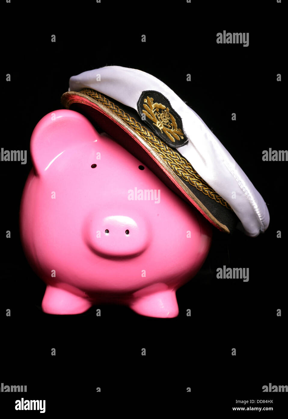 piggy bank wearing sailors hat on a black background Stock Photo