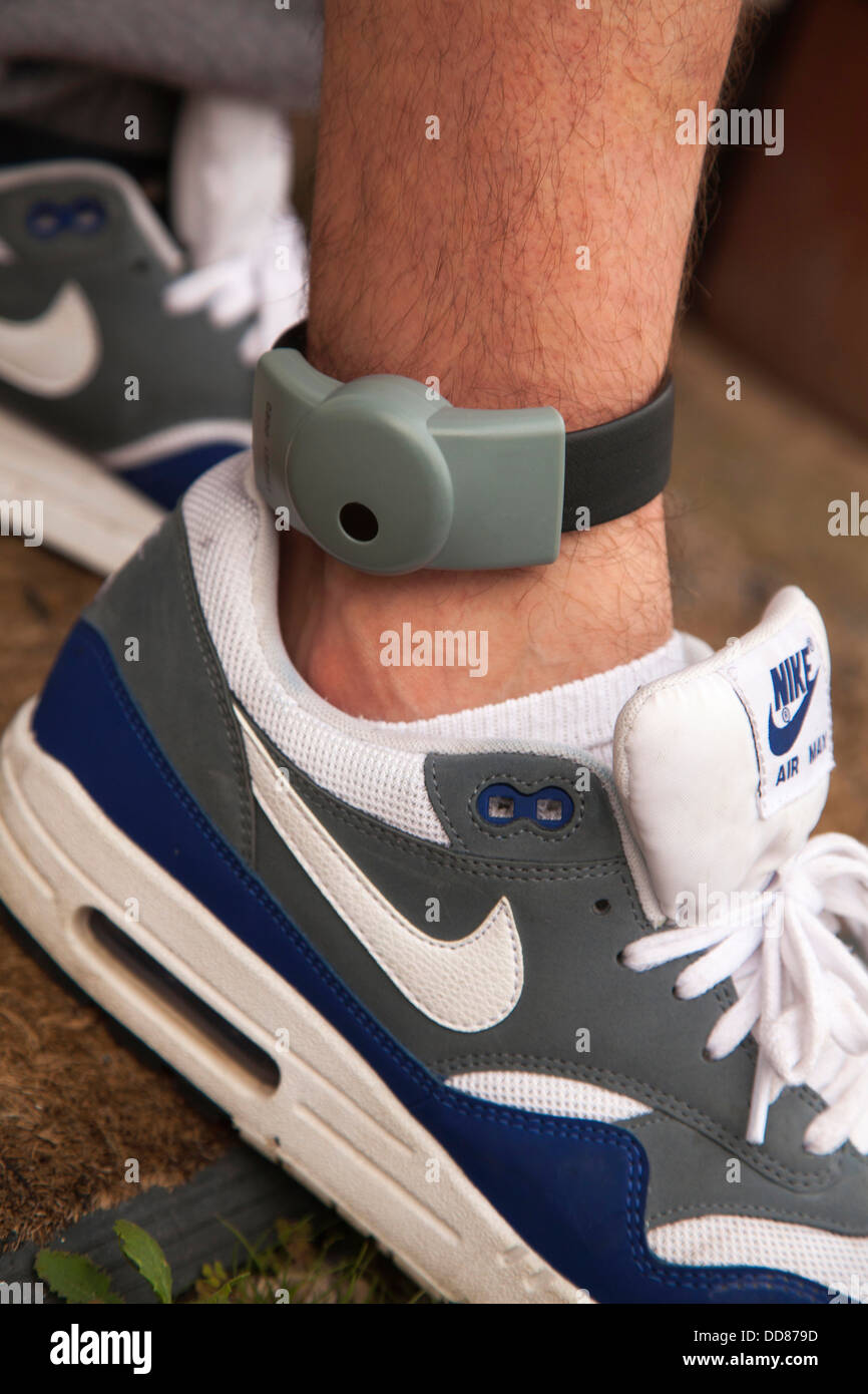 An electronic ankle tag on a teenage offender in the U.K. (identification number obscured). Stock Photo