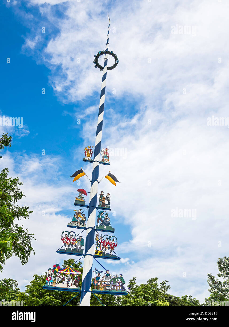 Picture of a typical traditional bavarian maypole with blue sky and white clouds Stock Photo