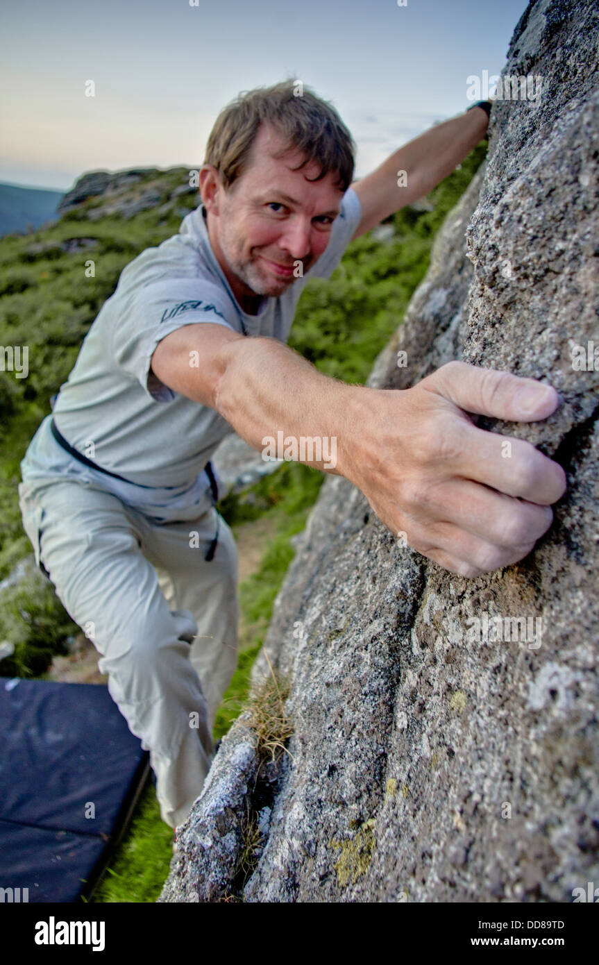 Rock Climber Jon Hawker bouldering at Tunhill Rocks on Dartmoor, a great bouldering location Stock Photo
