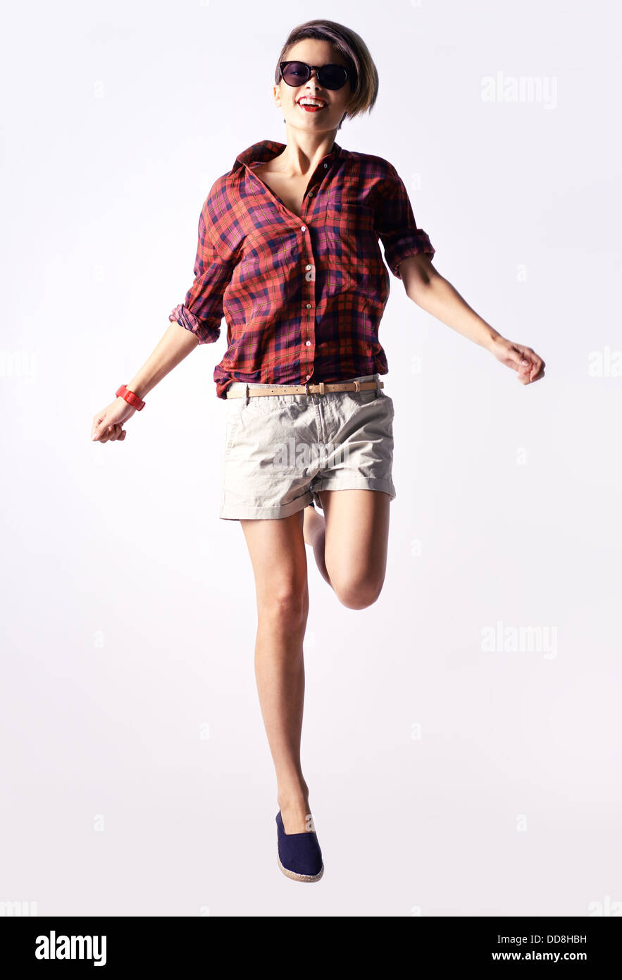 Vertical portrait of a carefree girl captured in a jump Stock Photo