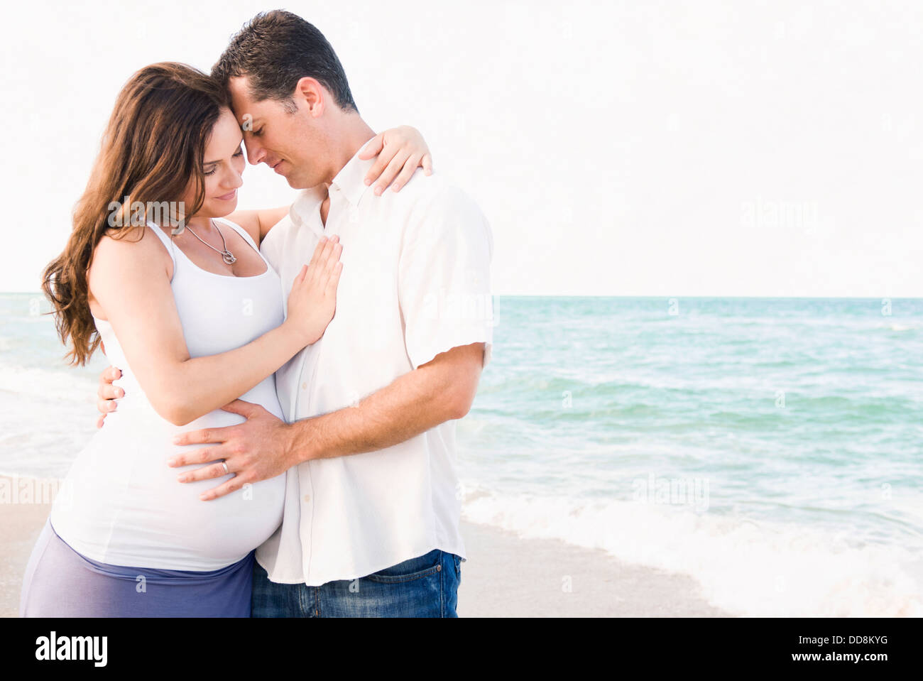 Caucasian man hugging pregnant wife on beach Stock Photo - Alamy