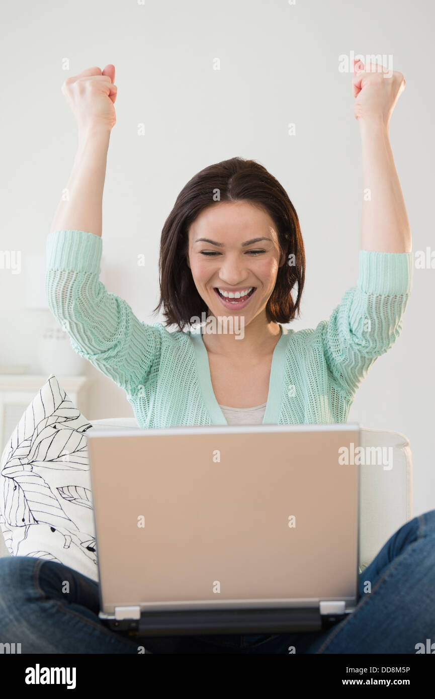 Caucasian woman cheering at laptop Stock Photo