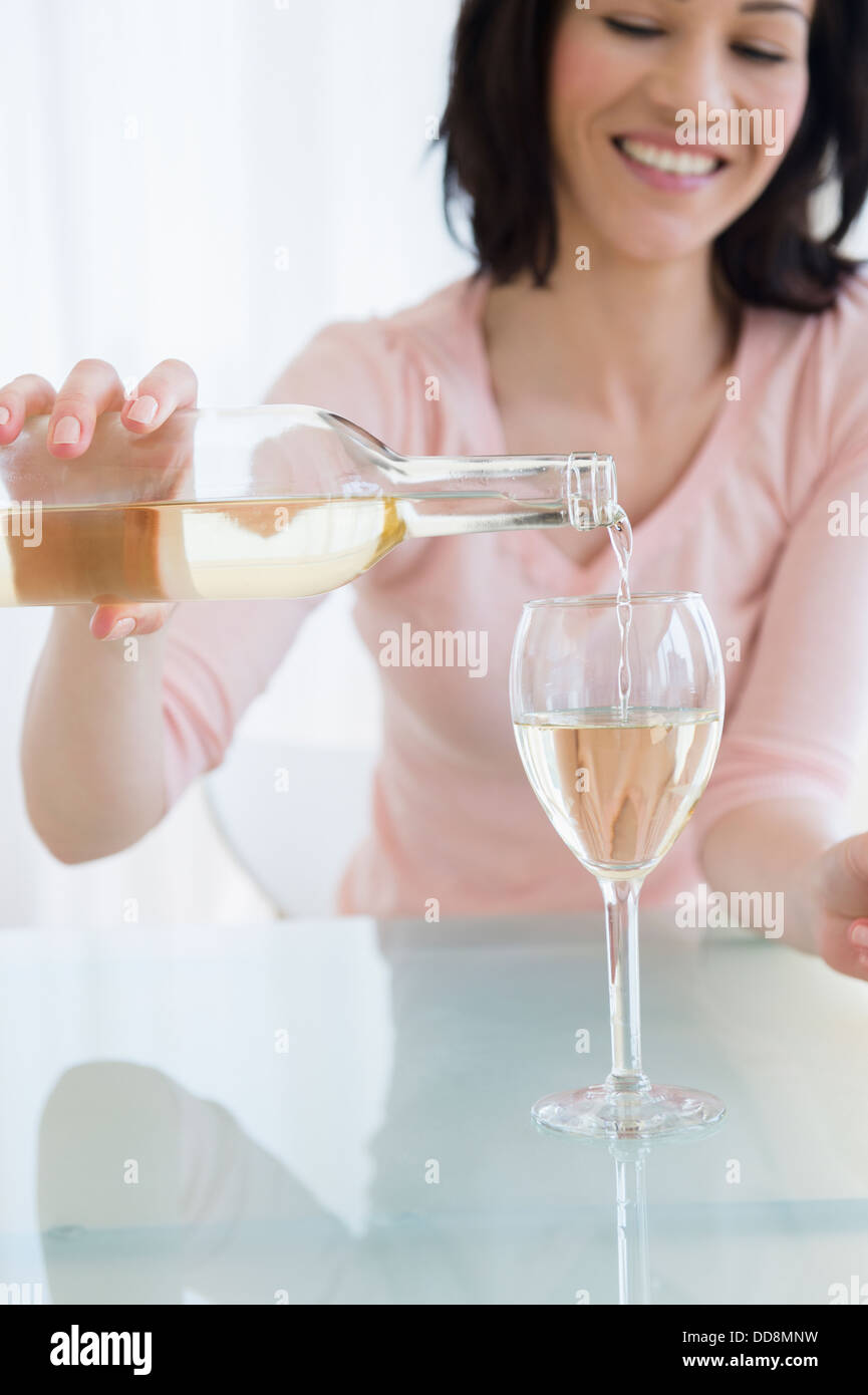 Caucasian woman pouring glass of wine Stock Photo - Alamy