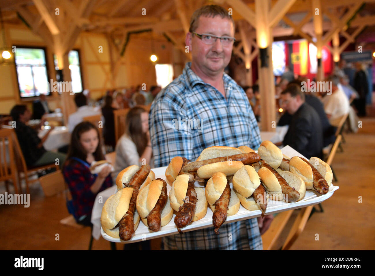 A man holds a tray of German Bratwurst in a bun in the 1st German