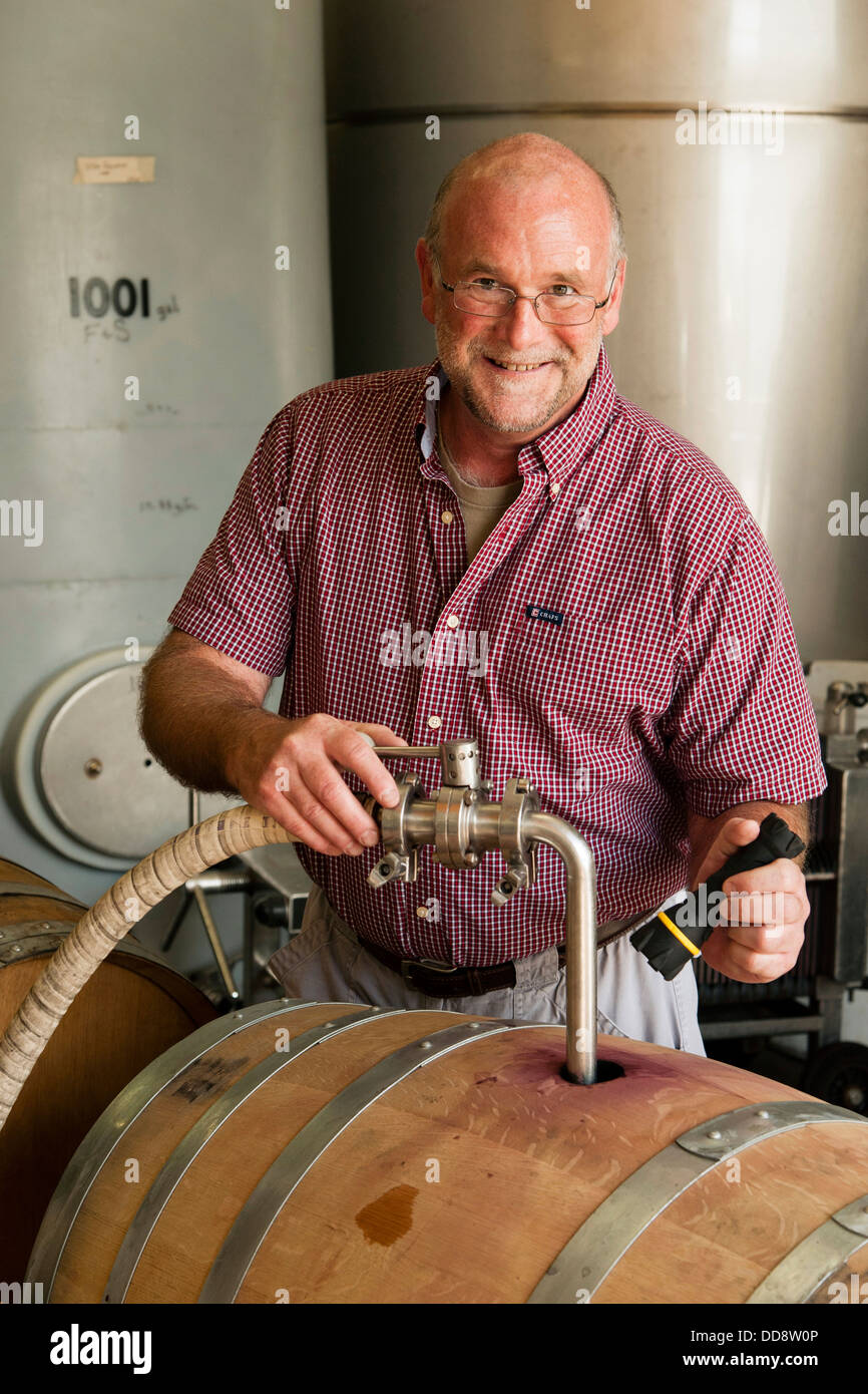 USA, Washington, Outlook. John Zimmerman, winemaker for Tefft Cellars uses a topping wand to