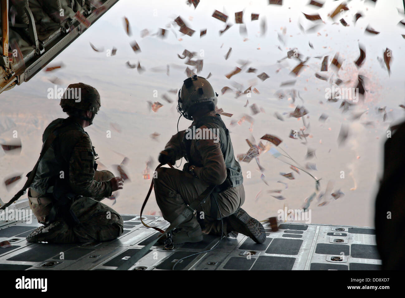 US Army psychological operations specialists watch leaflets fall off the back of a KC-130 Super Hercules during an operation to counter the influence of the Taliban August 28, 2013 over southern Afghanistan. Stock Photo