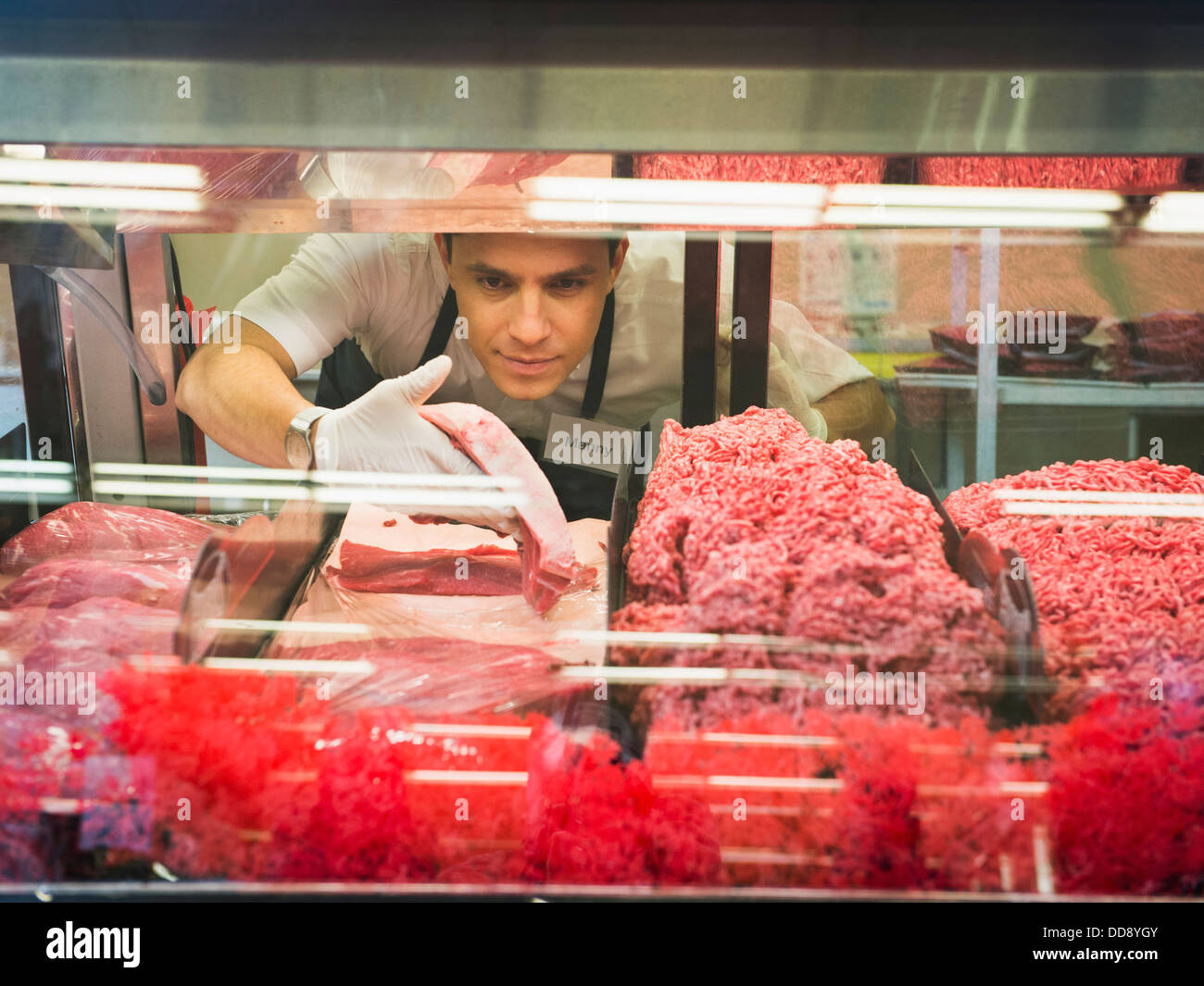 Hispanic butcher at meat counter of grocery store Stock Photo