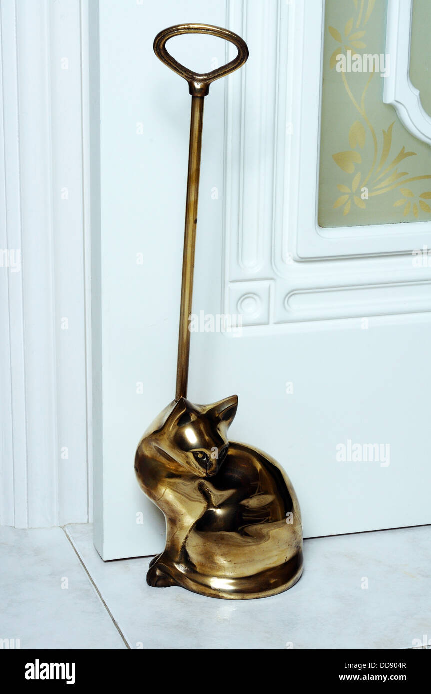 Brass cat doorstop against a white door, UK, Western Europe Stock Photo Alamy