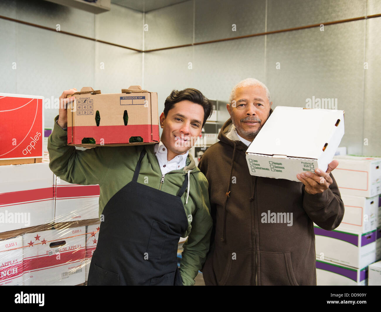 Workers carrying boxes in walk-in freezer Stock Photo