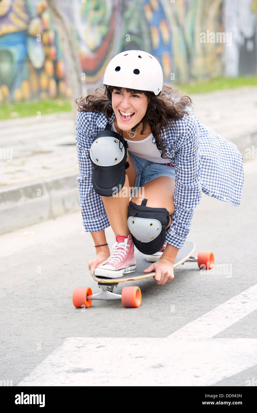 Hispanic woman riding skateboard Stock Photo