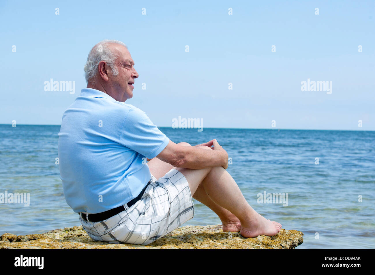 Hispanic man relaxing on beach Stock Photo