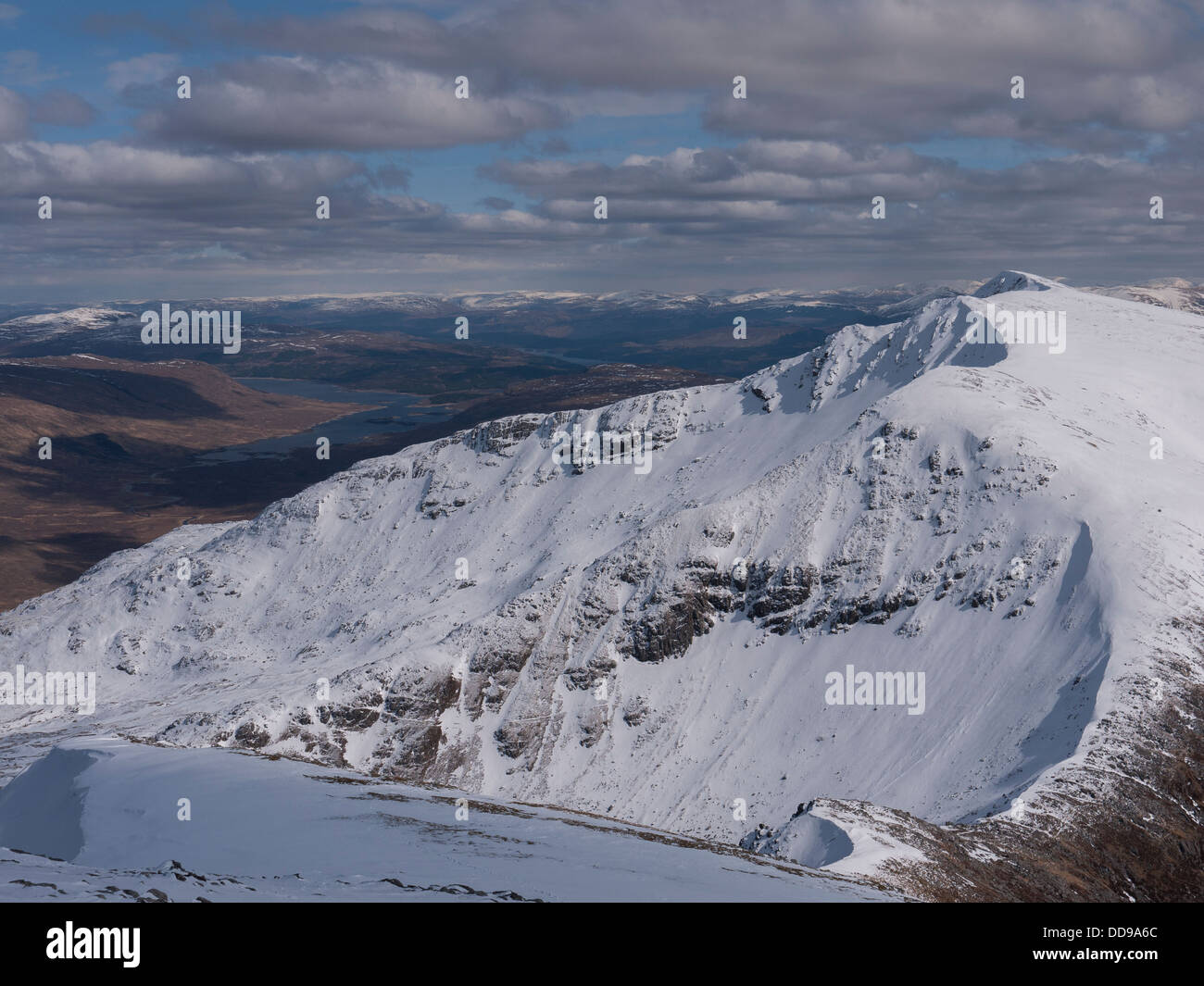 View towards the snowy mountain summit of Spidean Mialach in the Glenquoich Forest with Loch Loyne in the distance, Scotland UK Stock Photo