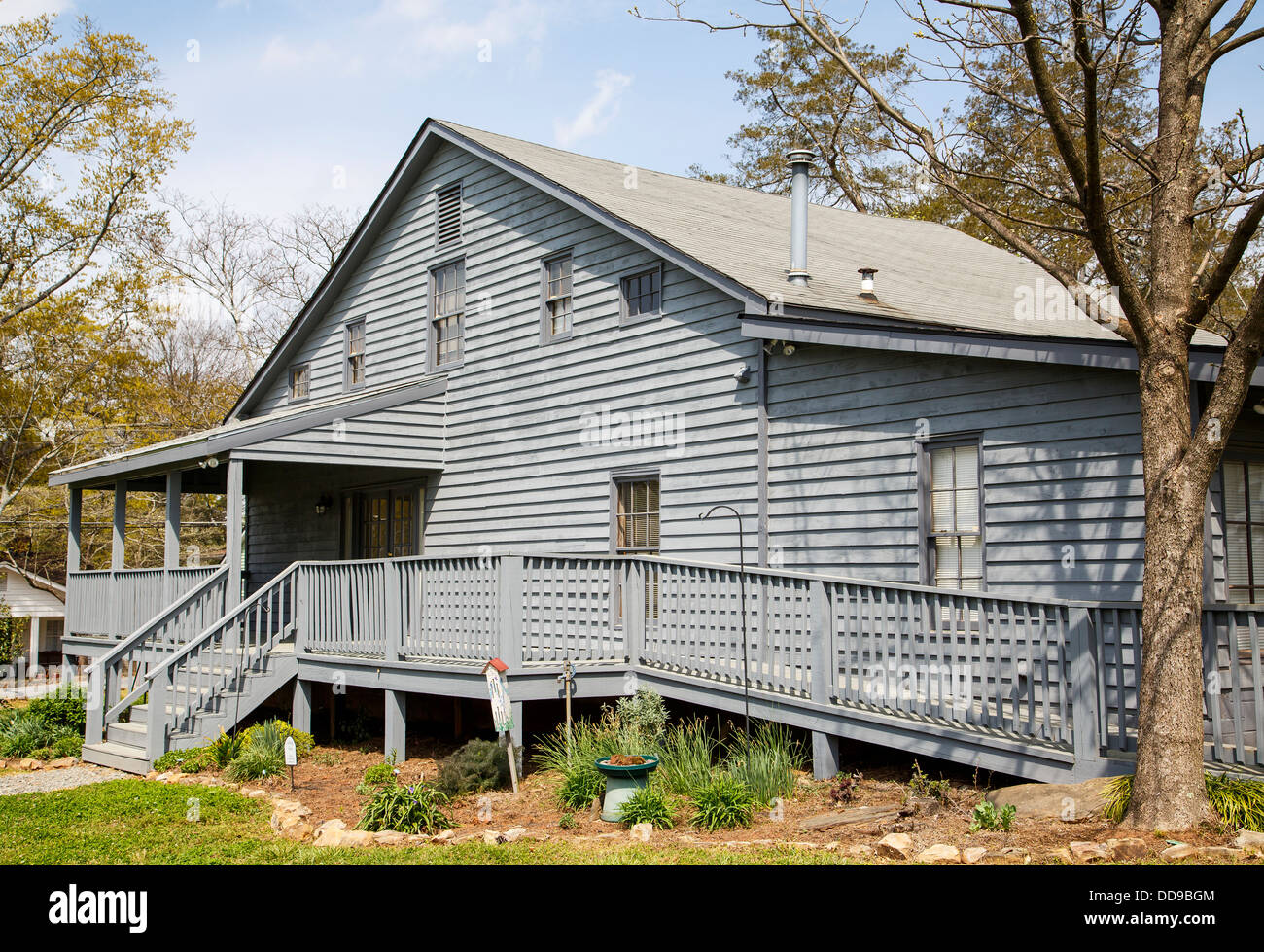 An old grey wood siding house with a wheelchair accessible ramp Stock Photo