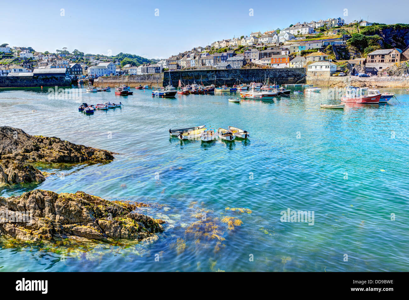 HDR of Boats in Cornwall harbour of Mevagissey with blue sea and sky Stock Photo