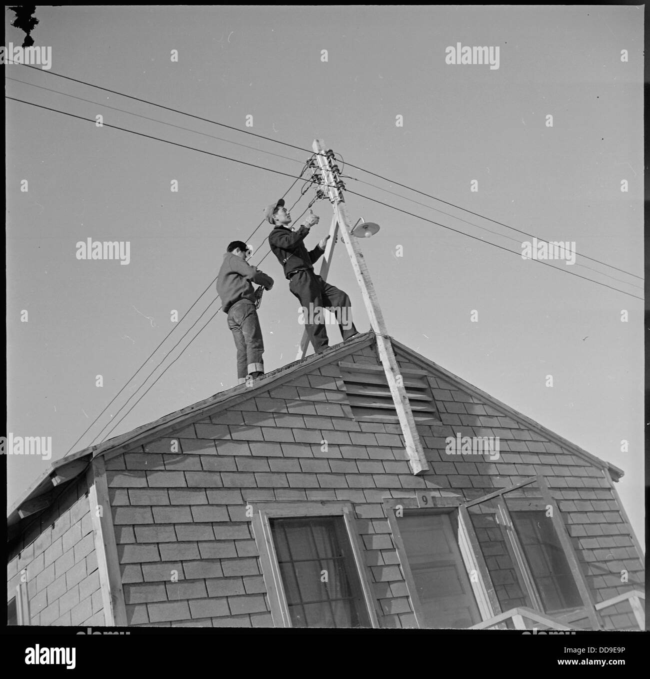 Heart Mountain Relocation Center, Heart Mountain, Wyoming. Two center electricians repair wires sli . . . - - 539225 Stock Photo