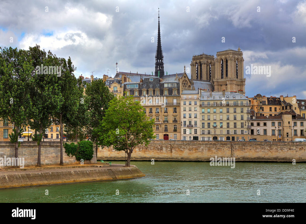 Notre Dame de Paris cathedral among typical parisian buildings along Seine river in Paris, France. Stock Photo