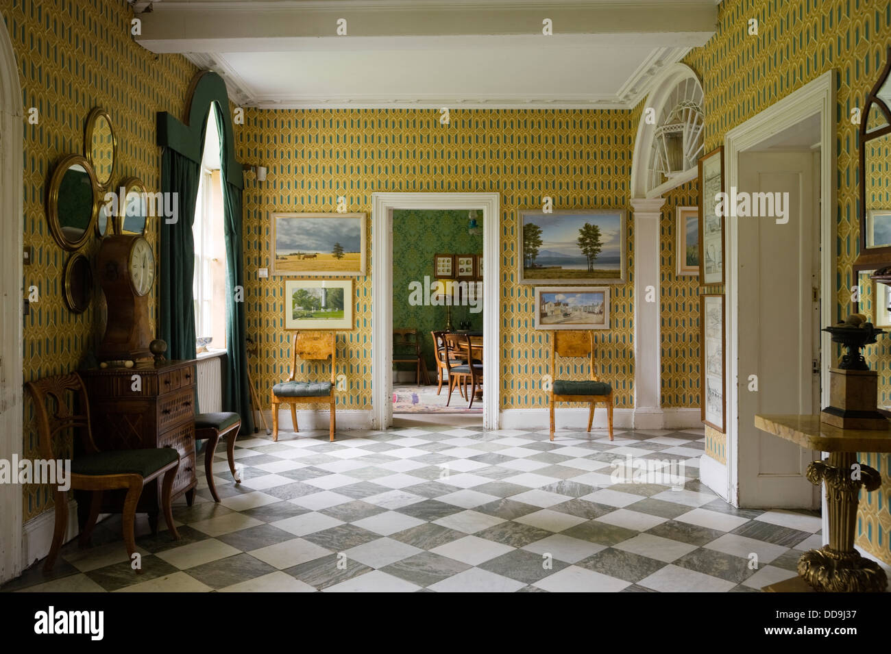 Wallpaper by Cole & Sons in hallway with 18th century furniture and marble flooring Stock Photo