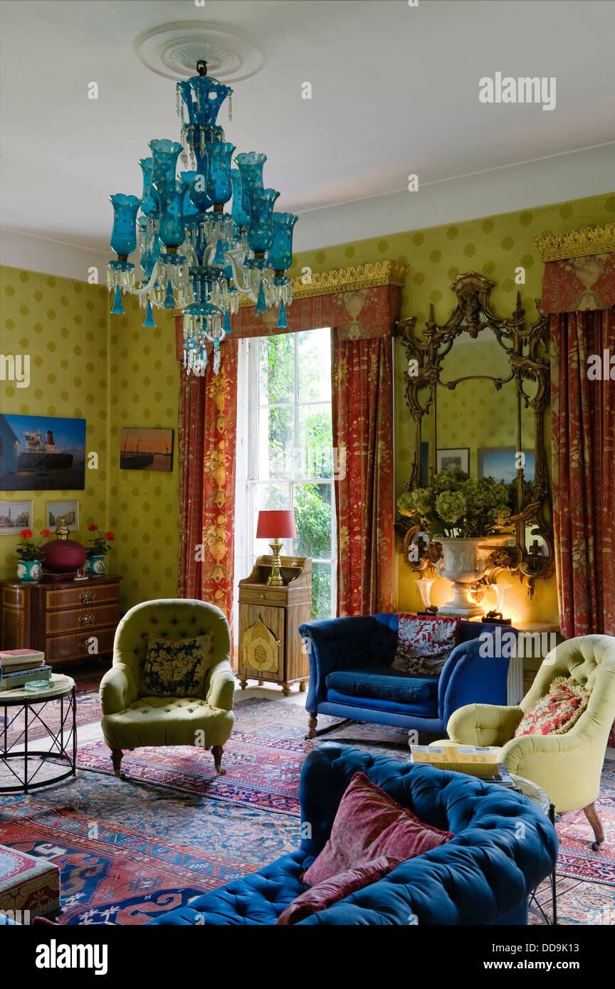 Sitting room wallpaper by Cole & Sons with contrasting blue upholstery and  cherry red chintz curtains Stock Photo - Alamy