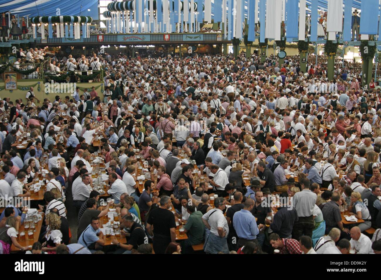 Germany Bavaria Munich Octoberfest large crowd group men and women in Bavarian costume enjoying a beer in an Oktoberfest Stock Photo