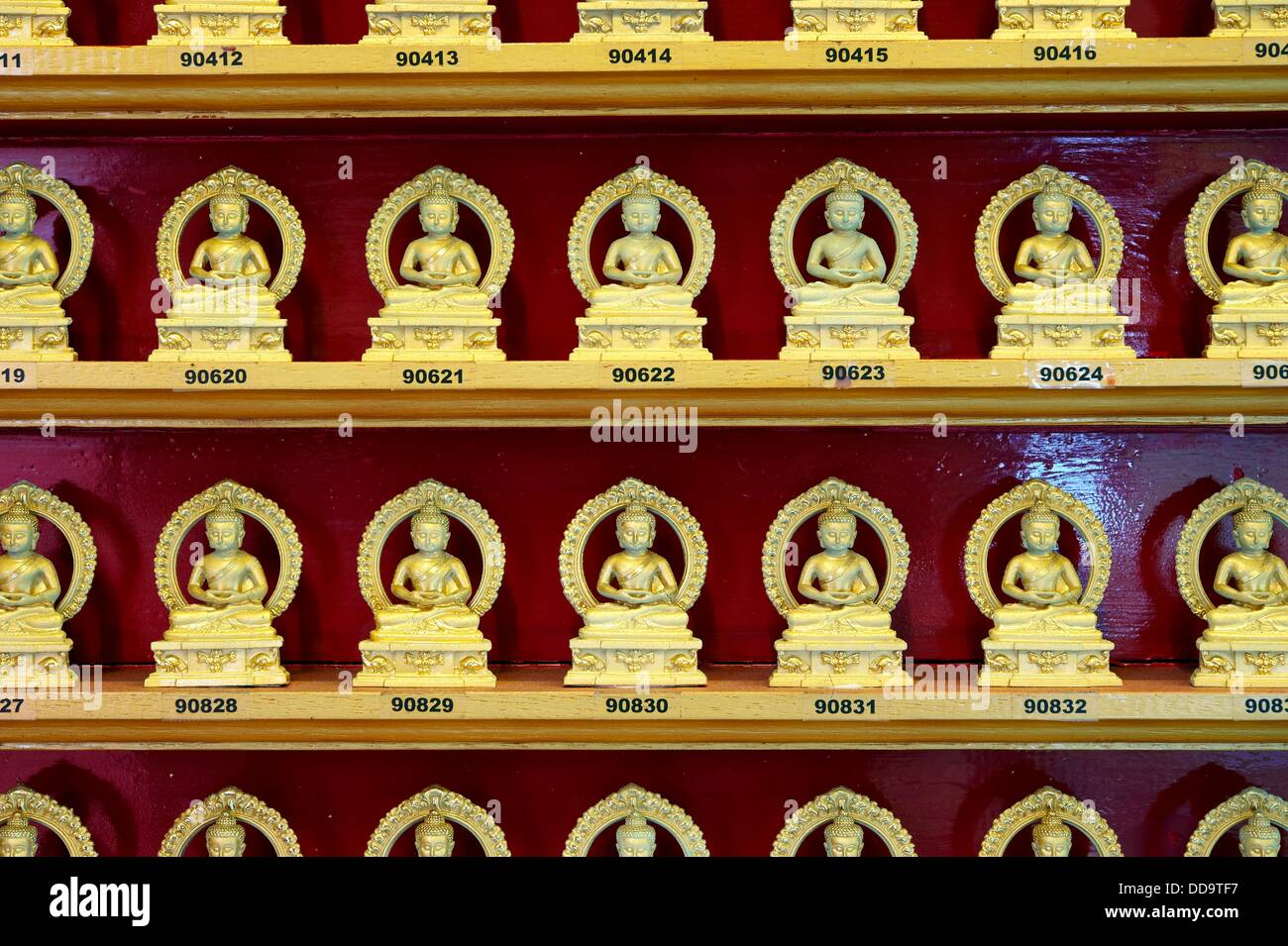 Numbered golden statues of Buddha while meditating in lotus position