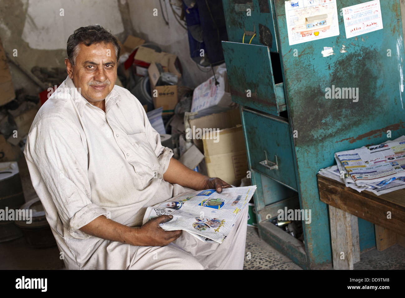 an pakistani man waiting for customer in a mechanical repairs